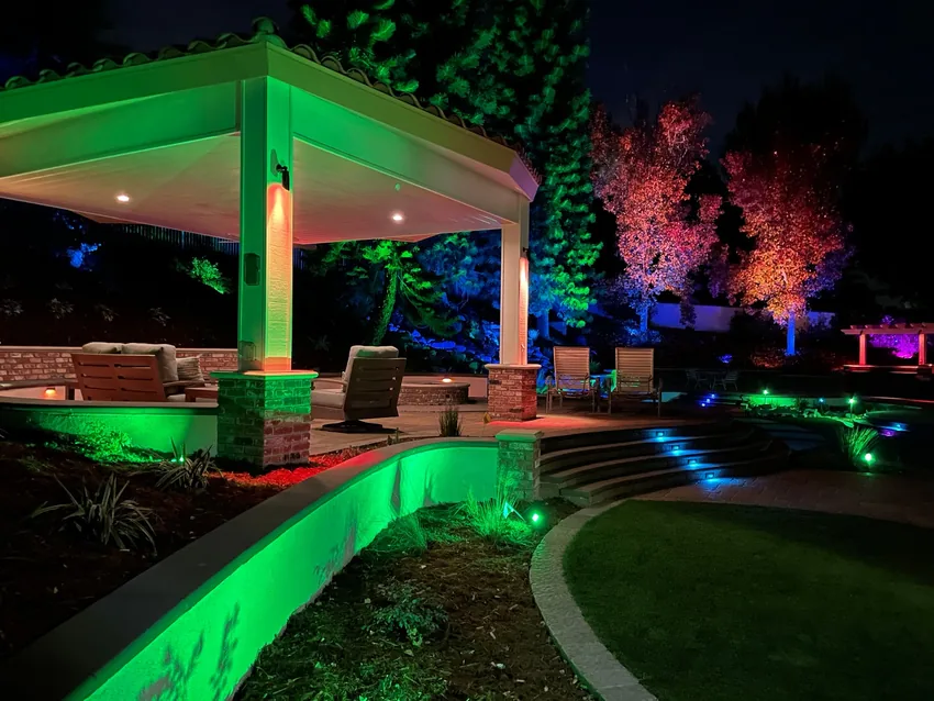 Backyard patio and landscape lit in green, blue and red app-controlled lighting